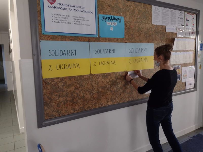 Nauczycielka wiesza napisa "Solidarni" z Ukrainą