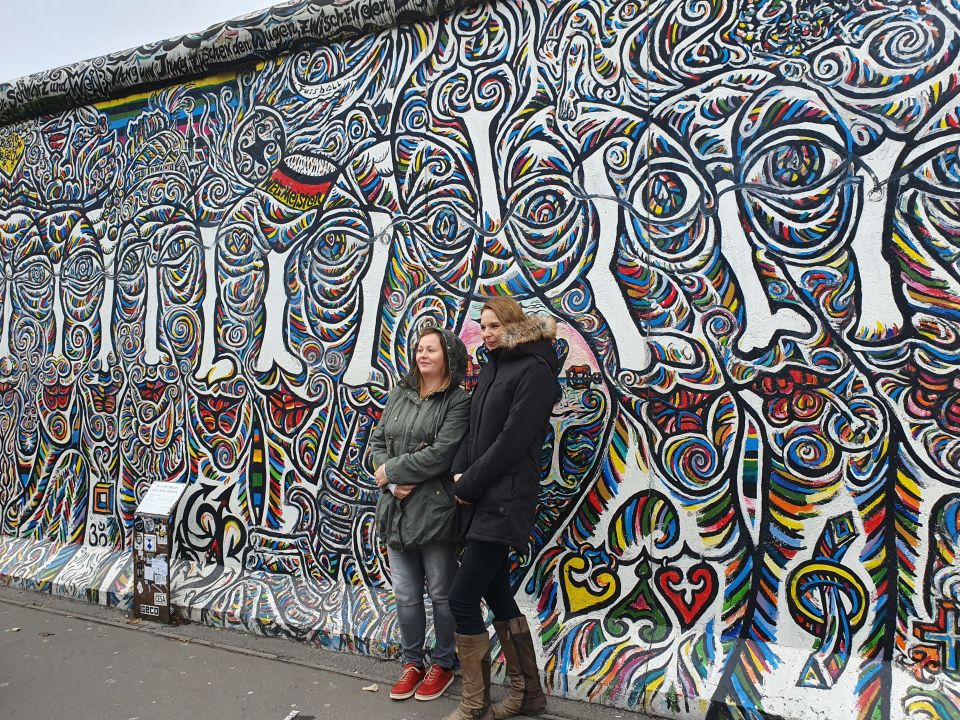 Dwie nauczycielki pozują na tle muru berlińskiego