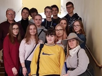 Grupa kilkunastu uczniów na schodach Uniwersytetu Wrocławskiego-w budynku