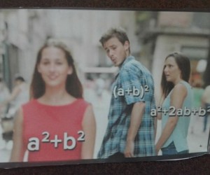 Dwójka młodych ludzi, chłopak i dziewczyna idą razem. Chłopak z lewej strony, ogląda się w lewo na inną dziewczynę, ubraną w czerwoną koszulkę bez rękawów. na dziewczynie jest napisany kawałek wzoru: a kwadrat + b kwadrat. Chłopak ubrany jest w niebieska koszulę w białą kratę. Na chłopaku jest kawałek wzoru: (a+b) do kwadratu. Dziewczyna, którą trzyma za rękę jest w jasnoniebieskiej koszulce bez rękawów. Na dziewczynie jest napis składający się z kawałka wzoru: a kwadrat+ 2ab+b kwadrat.
